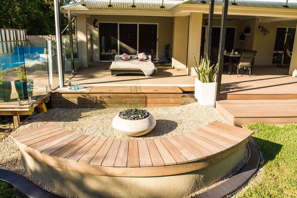 Contemporary backyard partial sun formal garden in Brisbane with a fire feature and gravel.