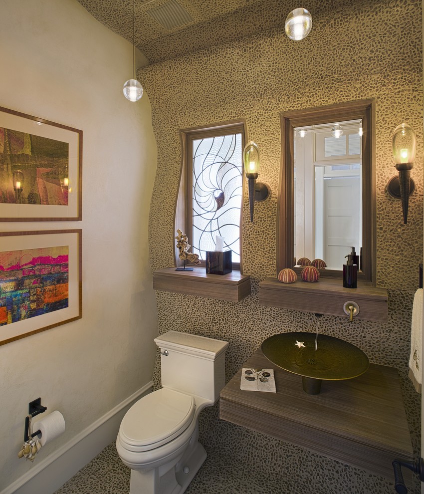 This is an example of a traditional powder room in Philadelphia with a vessel sink and pebble tile.
