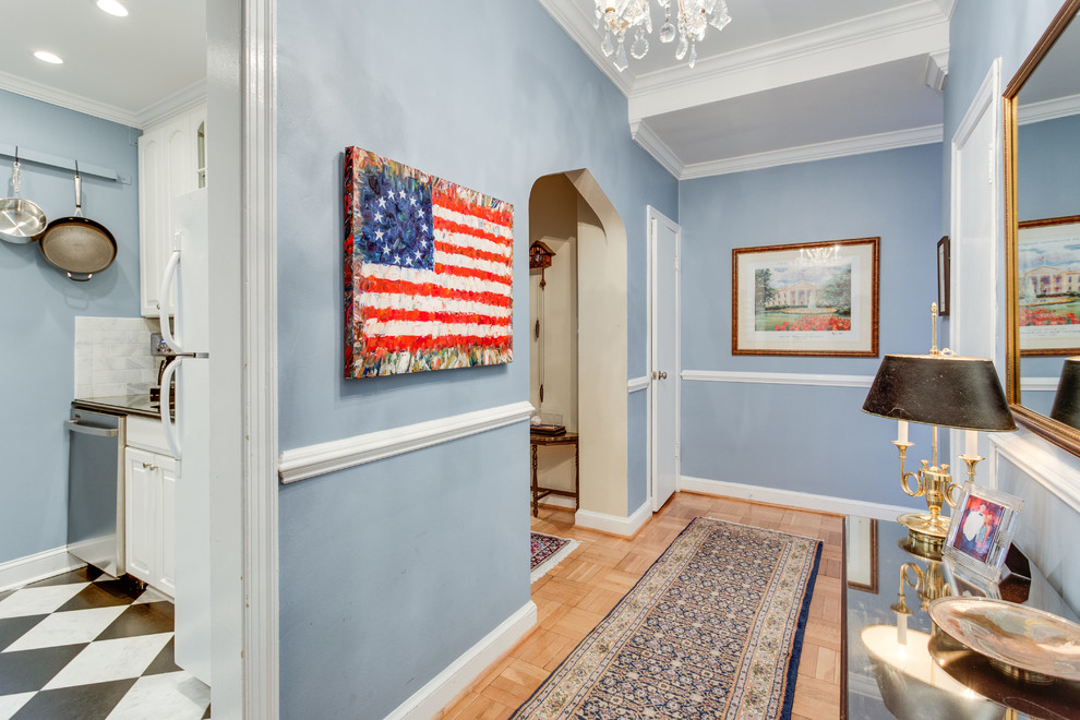 This is an example of a traditional hallway in DC Metro with blue walls and light hardwood floors.