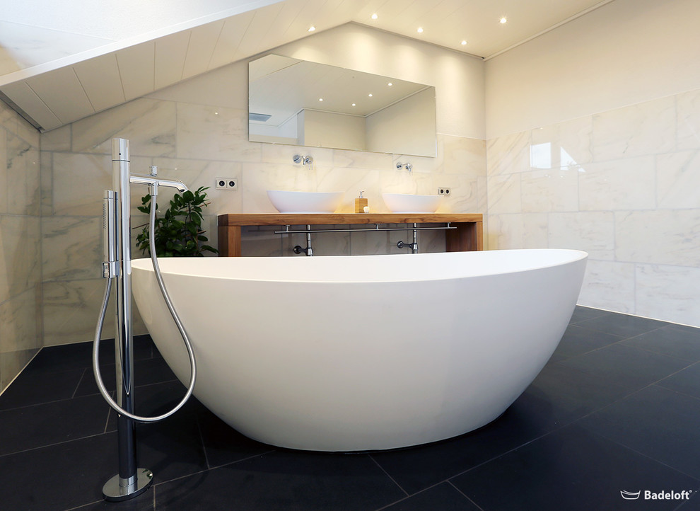 Modernes Badezimmer mit freistehender Badewanne und Mineralwerkstoff-Waschtisch in Berlin