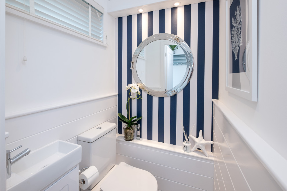 Design ideas for a small nautical bathroom in Hampshire with shaker cabinets, white cabinets, a one-piece toilet, white walls, laminate floors, white worktops, a single sink and a freestanding vanity unit.