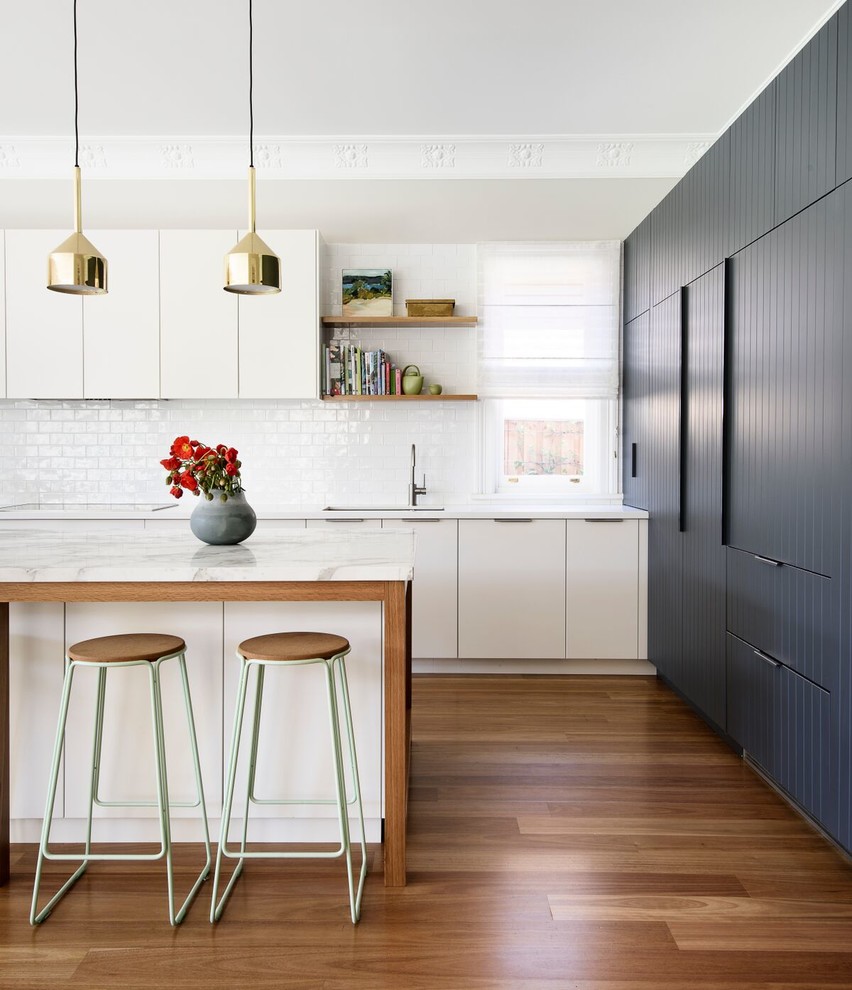 Photo of a large contemporary open plan kitchen in Sydney with flat-panel cabinets, grey cabinets, marble benchtops, white splashback, ceramic splashback, stainless steel appliances, with island and dark hardwood floors.