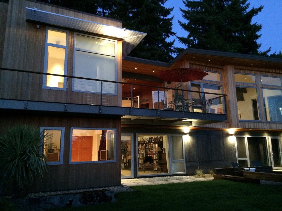 This is an example of a mid-sized midcentury two-storey exterior in Seattle with metal siding and a shed roof.