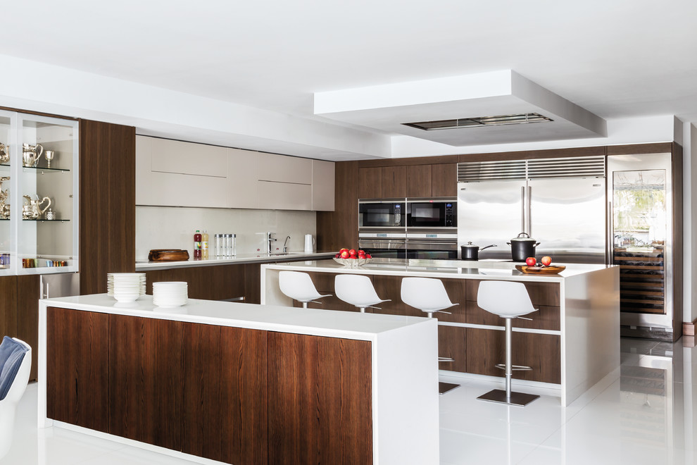 Contemporary kitchen in Miami with an undermount sink, flat-panel cabinets, dark wood cabinets, stainless steel appliances, multiple islands and white floor.