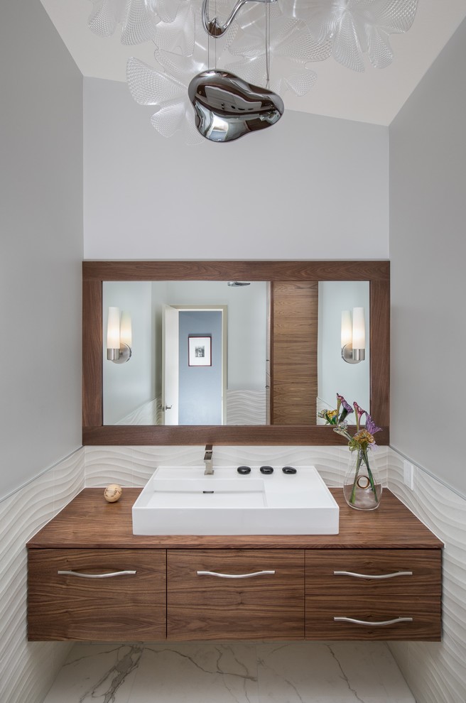 Small midcentury powder room in Denver with flat-panel cabinets, medium wood cabinets, a one-piece toilet, white tile, porcelain tile, grey walls, ceramic floors, a console sink, wood benchtops, white floor and white benchtops.