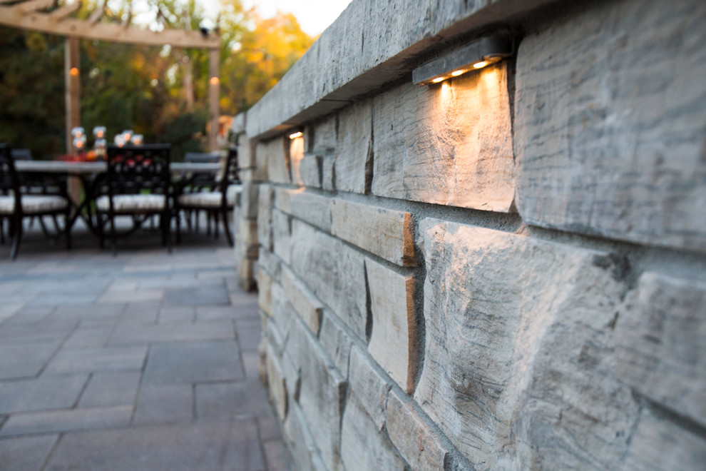 Photo of a transitional backyard stone water fountain landscape in Omaha.