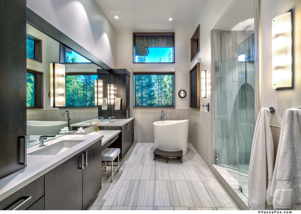 Photo of a modern bathroom in Other with flat-panel cabinets, a freestanding tub, an alcove shower, porcelain tile, white walls, porcelain floors, an undermount sink, solid surface benchtops, a hinged shower door, a double vanity and a built-in vanity.