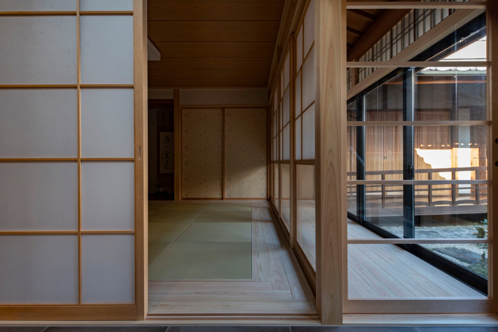Aménagement d'un grand salon fermé avec une salle de réception, un mur blanc, un sol de tatami, aucune cheminée, aucun téléviseur, un sol vert et un plafond en bois.