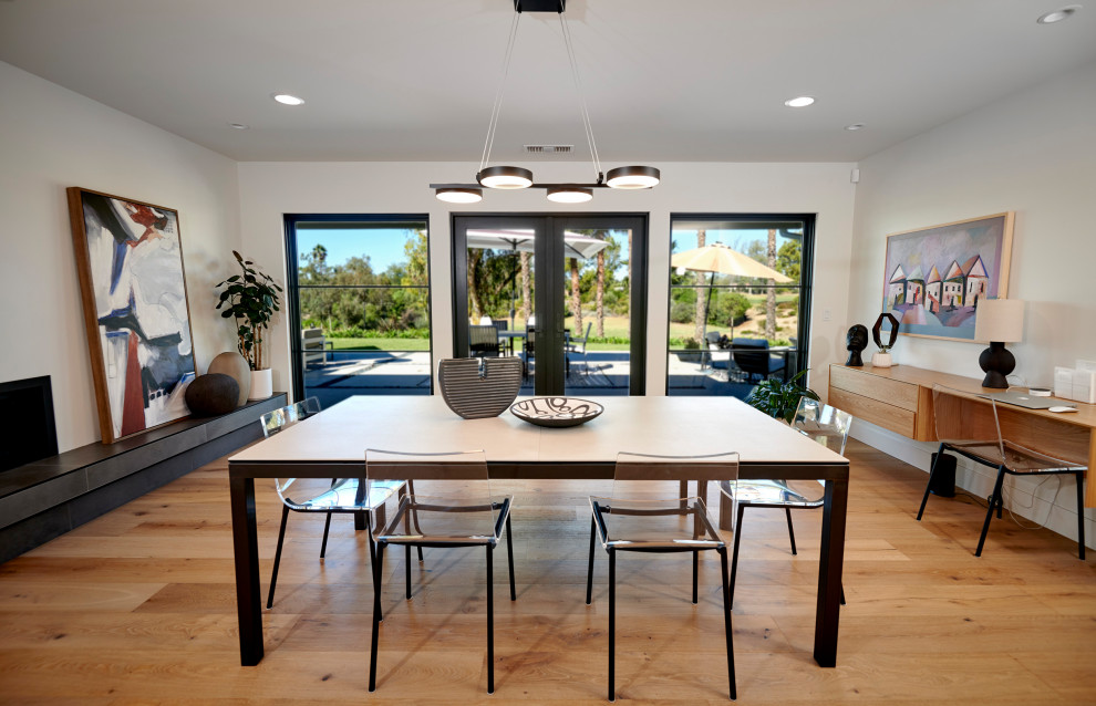 Foto di una grande sala da pranzo aperta verso il soggiorno minimalista con parquet chiaro e pavimento marrone