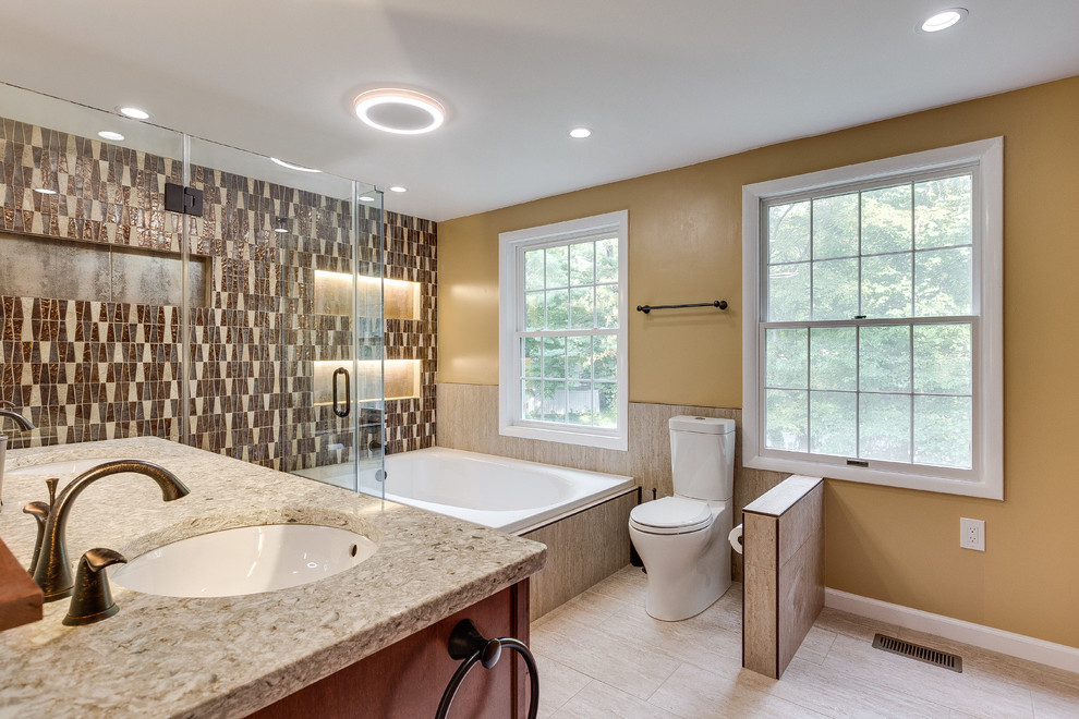 Large traditional master bathroom in DC Metro with raised-panel cabinets, medium wood cabinets, a corner tub, a corner shower, a two-piece toilet, beige tile, brown tile, ceramic tile, beige walls, bamboo floors, an undermount sink and granite benchtops.