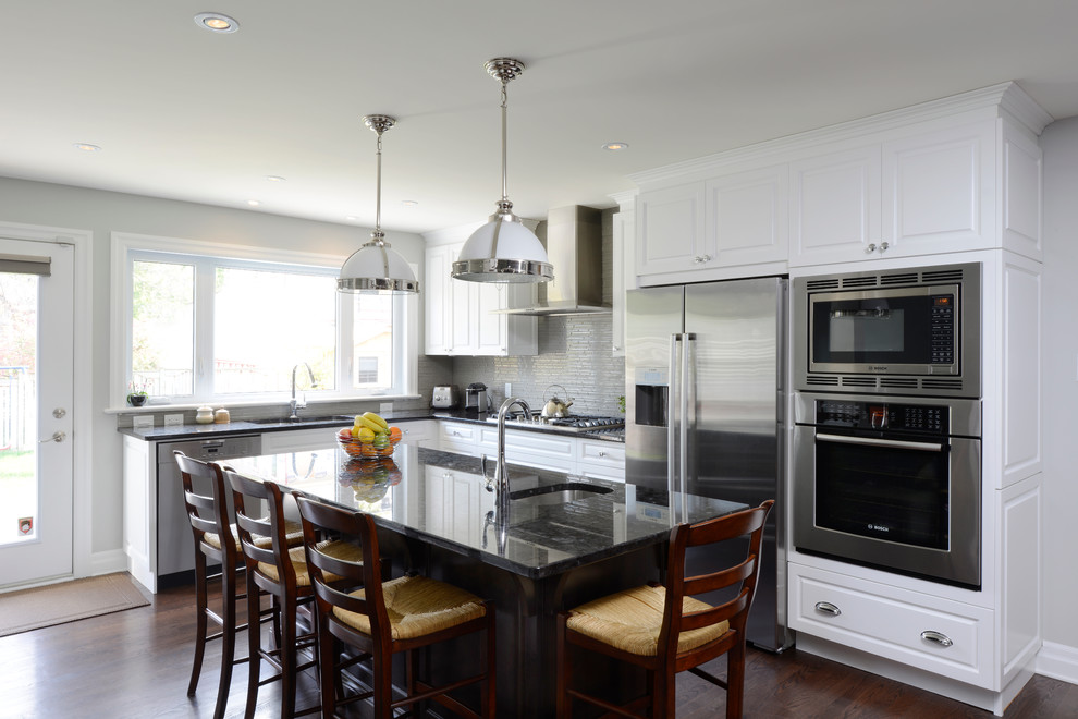 Inspiration for a mid-sized transitional l-shaped dark wood floor eat-in kitchen remodel in Ottawa with a single-bowl sink, raised-panel cabinets, white cabinets, granite countertops, gray backsplash, ceramic backsplash, stainless steel appliances and an island