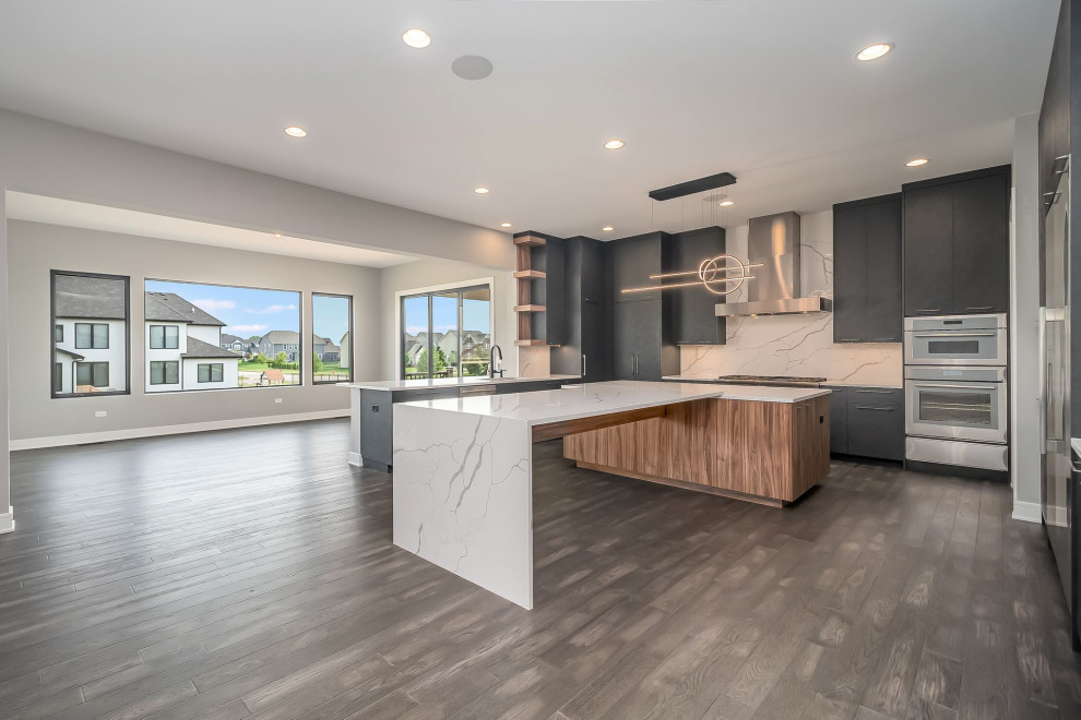 Huge l-shaped brown floor eat-in kitchen photo in Chicago with black cabinets, granite countertops, stainless steel appliances, two islands and white countertops