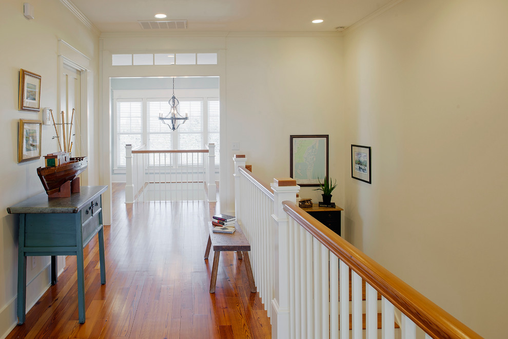 This is an example of a large beach style hallway in Charleston with white walls and medium hardwood floors.