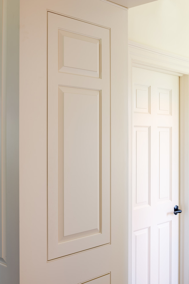 Photo of a small traditional built-in wardrobe in Philadelphia with raised-panel cabinets and white cabinets.