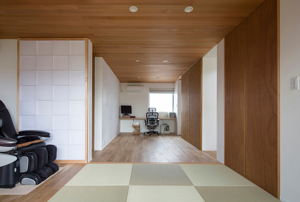 This is an example of a large bedroom in Other with white walls, tatami floors and wood.