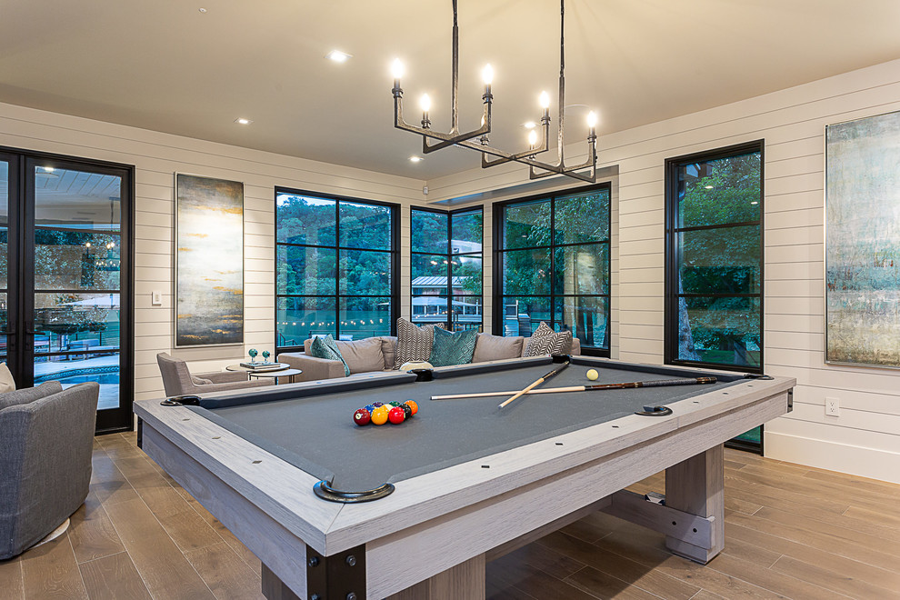 Inspiration for a mid-sized country open concept family room in Austin with a game room, white walls, medium hardwood floors, no fireplace and brown floor.