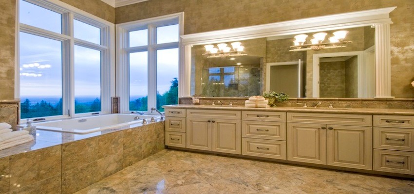 This is an example of a large traditional master bathroom in Seattle with an undermount sink, flat-panel cabinets, white cabinets, granite benchtops, a drop-in tub, white tile, porcelain tile, white walls and porcelain floors.