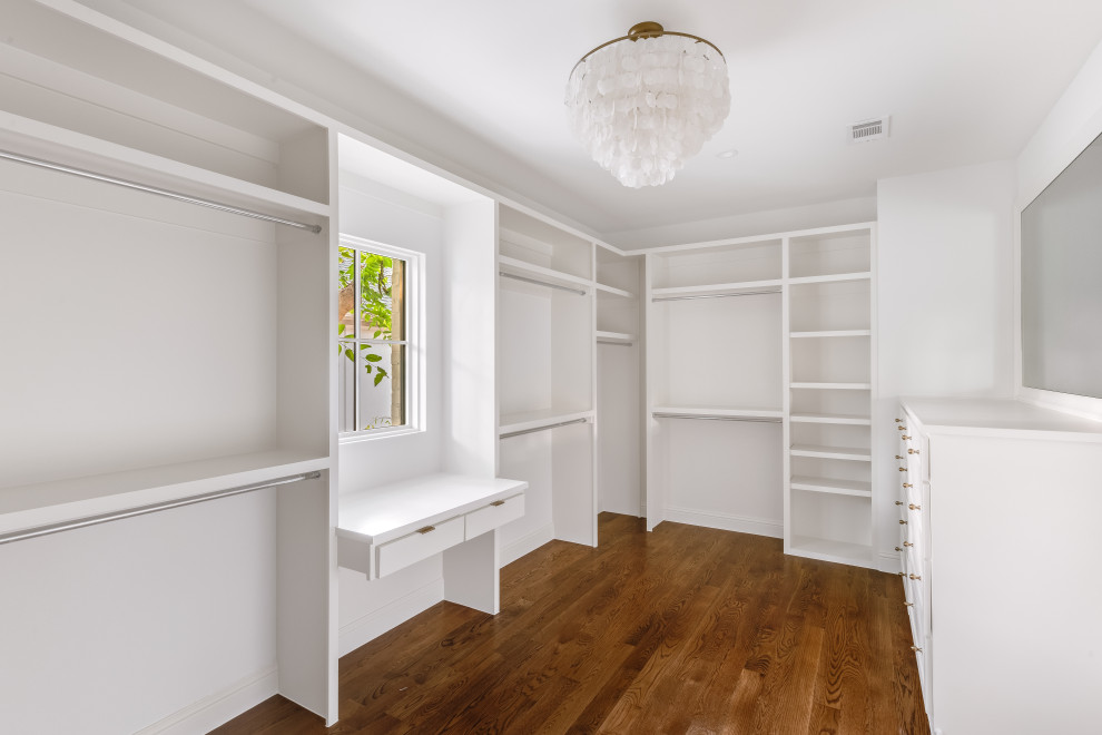 Design ideas for a large transitional gender-neutral walk-in wardrobe in Dallas with shaker cabinets, white cabinets, medium hardwood floors and brown floor.
