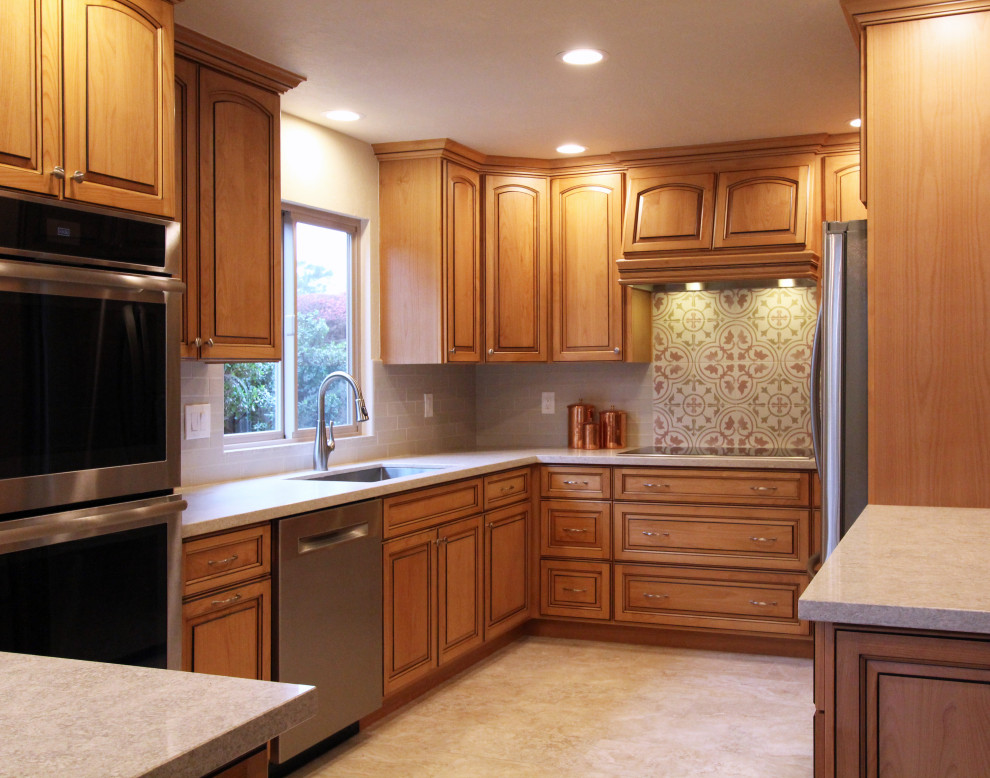 Eat-in kitchen - mid-sized u-shaped porcelain tile and beige floor eat-in kitchen idea with an undermount sink, raised-panel cabinets, medium tone wood cabinets, quartz countertops, multicolored backsplash, ceramic backsplash, stainless steel appliances, a peninsula and multicolored countertops