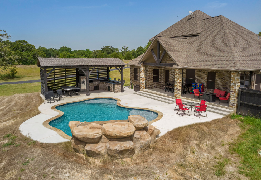 Inspiration for a mid-sized rustic backyard concrete and custom-shaped natural pool remodel