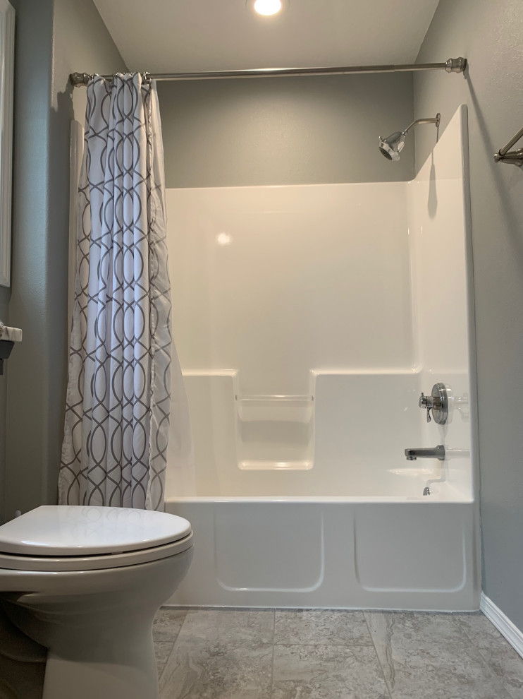 Aménagement d'une petite salle de bain avec un placard à porte shaker, des portes de placard bleues, une baignoire en alcôve, WC séparés, un mur gris, un sol en vinyl, un lavabo intégré, un plan de toilette en surface solide, un sol gris, un plan de toilette blanc, meuble simple vasque et meuble-lavabo sur pied.