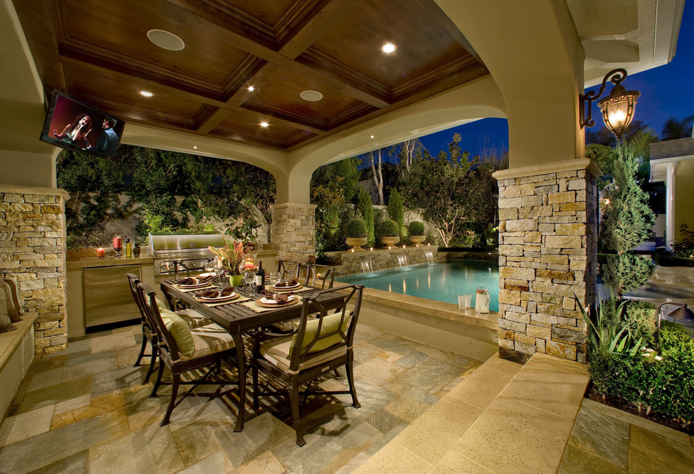 Large traditional backyard patio in Los Angeles with an outdoor kitchen, natural stone pavers and a gazebo/cabana.