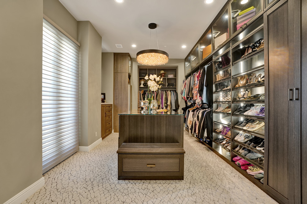 Mid-sized contemporary gender-neutral walk-in wardrobe in Orange County with shaker cabinets, medium wood cabinets, carpet and beige floor.