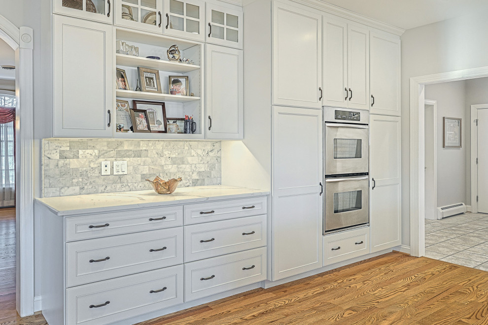 Huge transitional u-shaped medium tone wood floor and brown floor eat-in kitchen photo with an undermount sink, beaded inset cabinets, dark wood cabinets, quartz countertops, multicolored backsplash, marble backsplash, stainless steel appliances, an island and white countertops