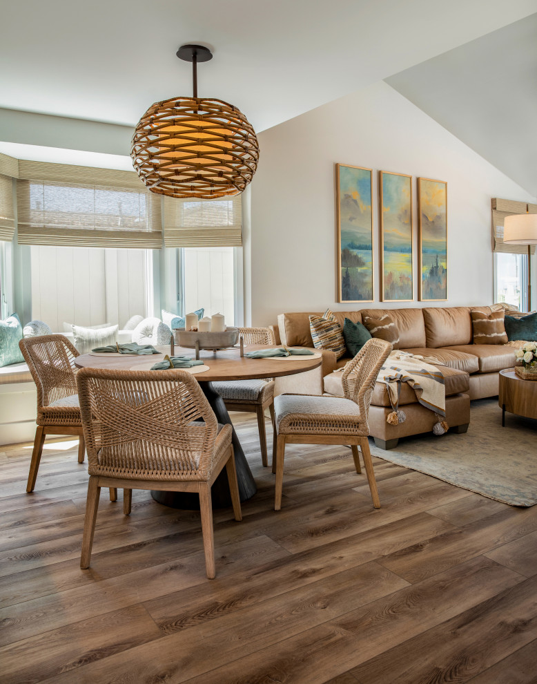 Large beach style open plan dining in Orange County with white walls, laminate floors, grey floor and vaulted.