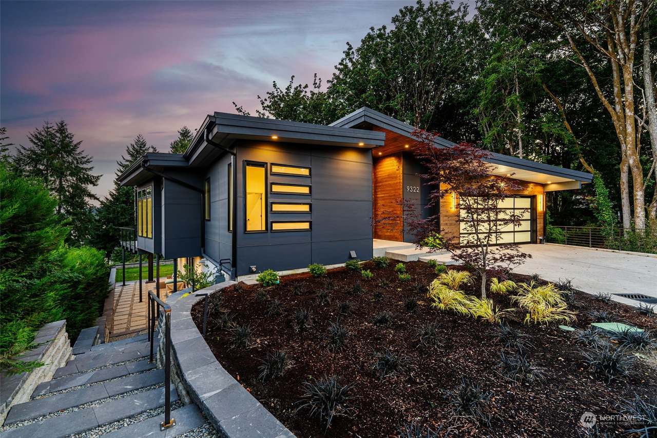 The night view of Goodman highlights its sleek, modern architecture with strategically placed exterior lighting. The combination of white and dark grey siding adds to the home’s sophisticated curb app