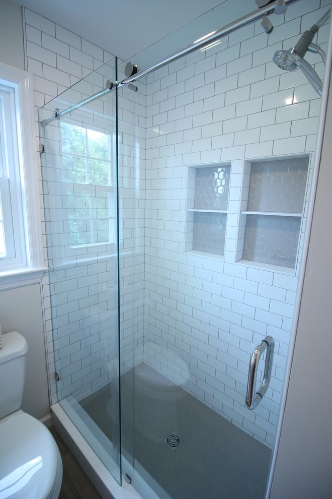 Photo of a small traditional kids bathroom in Other with shaker cabinets, white cabinets, an alcove shower, a two-piece toilet, white tile, ceramic tile, beige walls, vinyl floors, a trough sink, engineered quartz benchtops, beige floor, a sliding shower screen and beige benchtops.