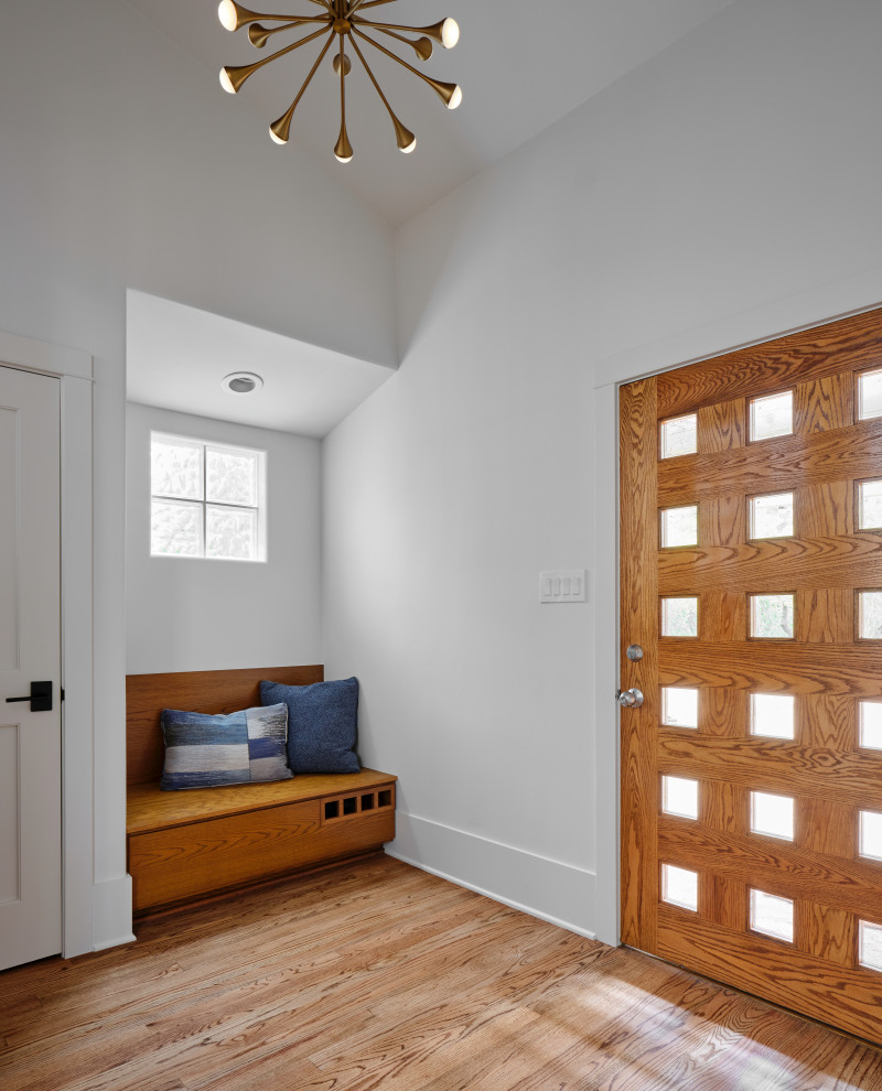 Retro Eingang mit weißer Wandfarbe, braunem Holzboden, braunem Boden und gewölbter Decke in Austin