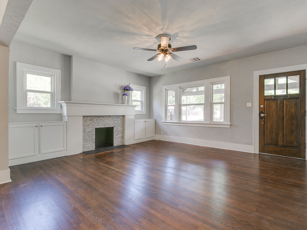 This is an example of a mid-sized arts and crafts foyer in Oklahoma City with grey walls, dark hardwood floors, a single front door, a dark wood front door and brown floor.