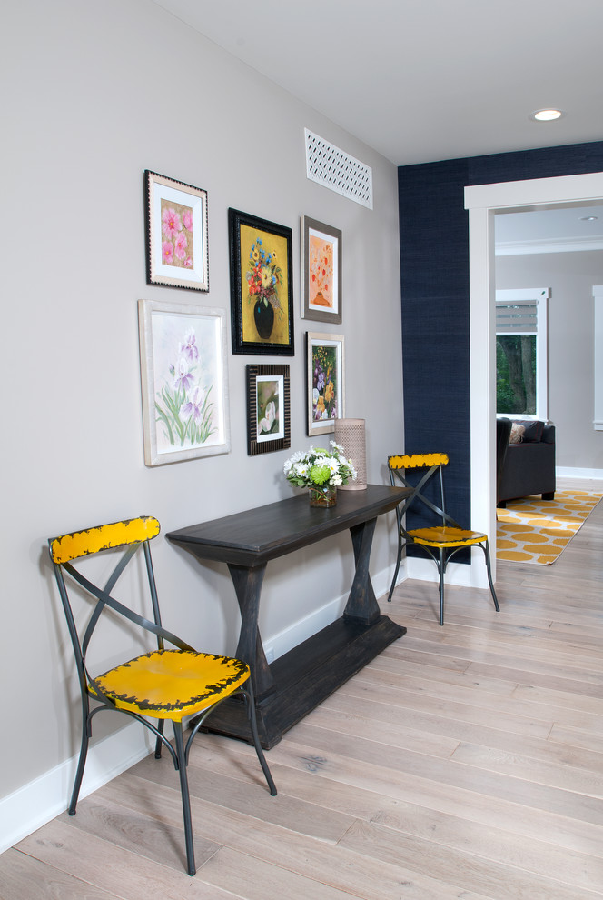 Photo of a mid-sized traditional foyer in Grand Rapids with grey walls, light hardwood floors and a single front door.