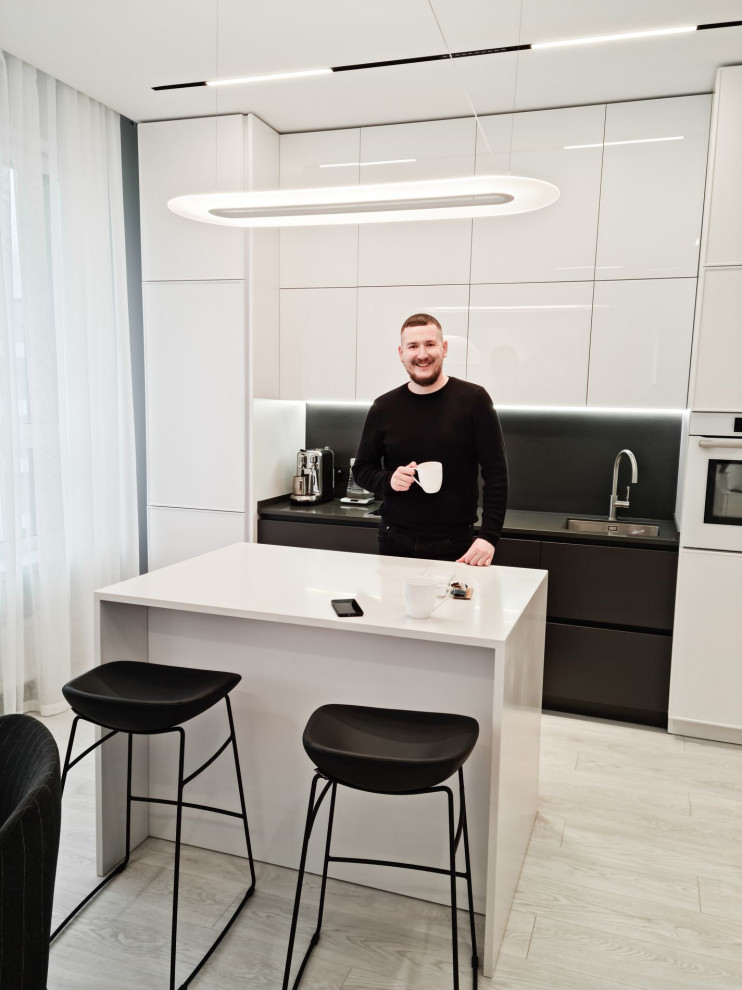 This is an example of a small contemporary single-wall open plan kitchen in Moscow with an undermount sink, black splashback, white appliances, with island, white floor and vinyl floors.