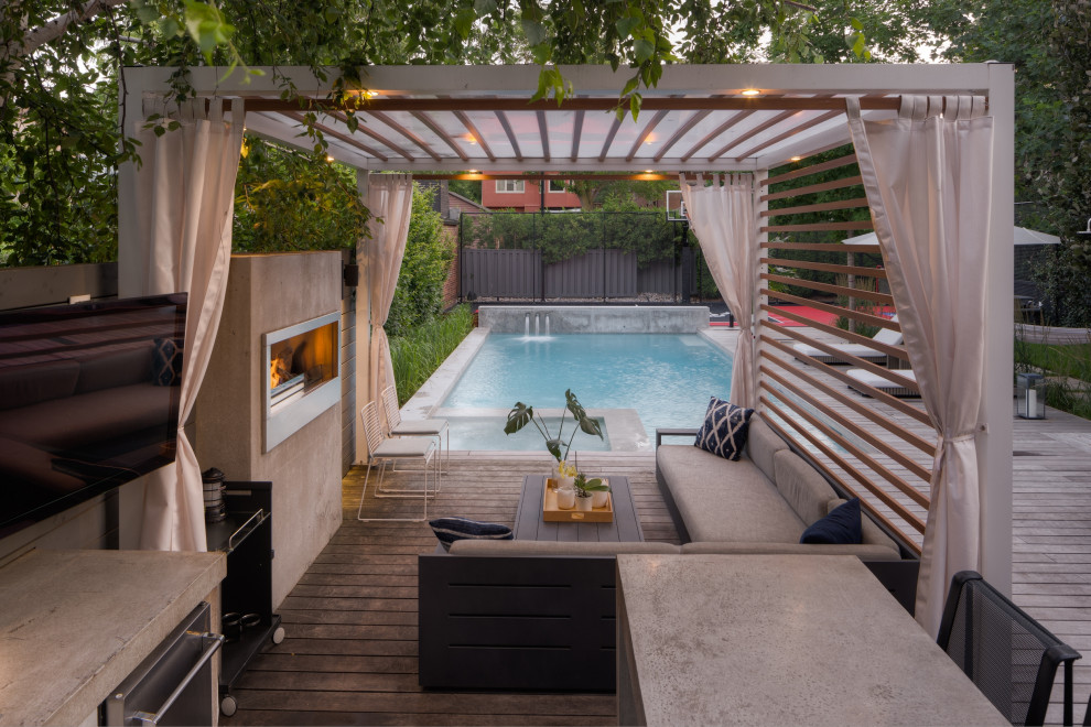 Medium sized industrial back patio in Toronto with a fireplace, decking and a pergola.