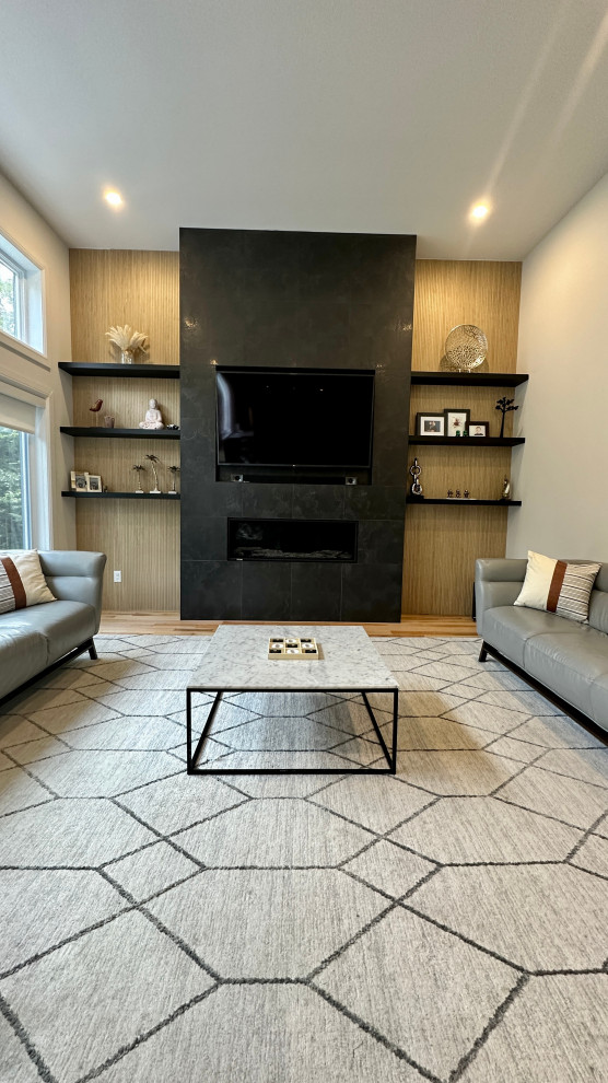 This is an example of a large midcentury formal open concept living room in Montreal with white walls, light hardwood floors, a standard fireplace, a tile fireplace surround, a wall-mounted tv and vaulted.