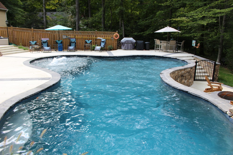 Pool fountain - large rustic backyard custom-shaped natural pool fountain idea in DC Metro with decking