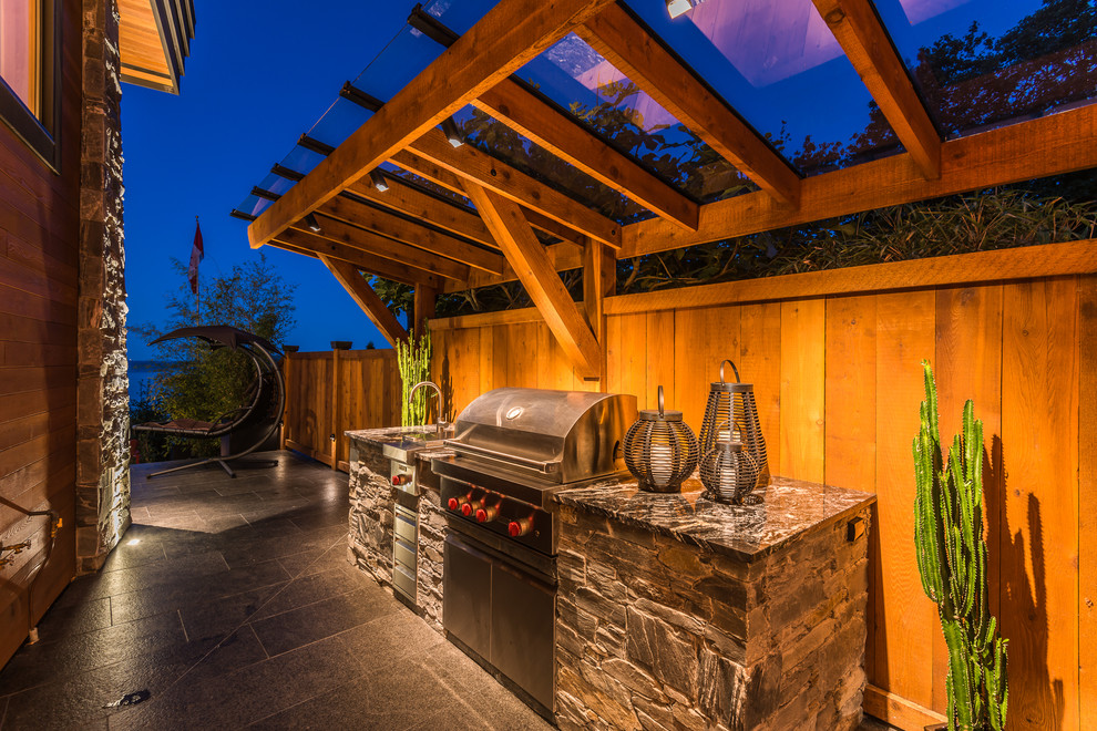 Photo of a mid-sized transitional side yard patio in Vancouver with an outdoor kitchen, tile and a pergola.