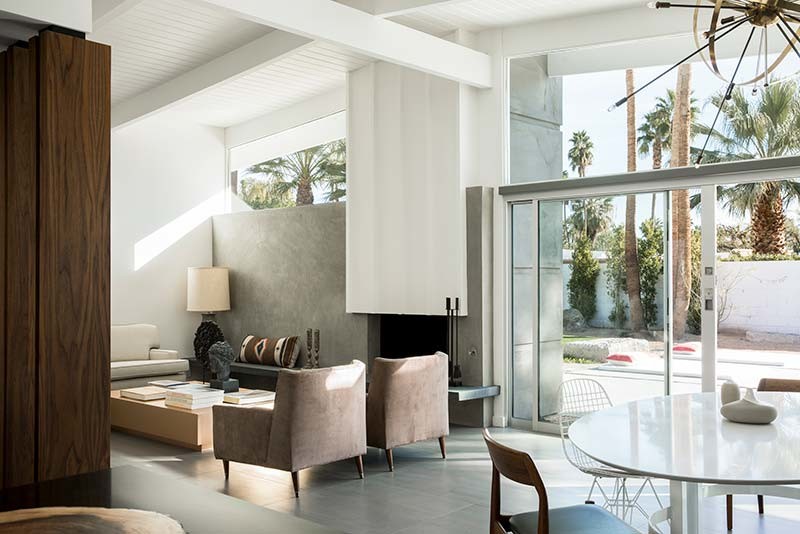 Design ideas for a mid-sized midcentury open concept living room in Los Angeles with white walls, porcelain floors, a standard fireplace, a concrete fireplace surround and no tv.