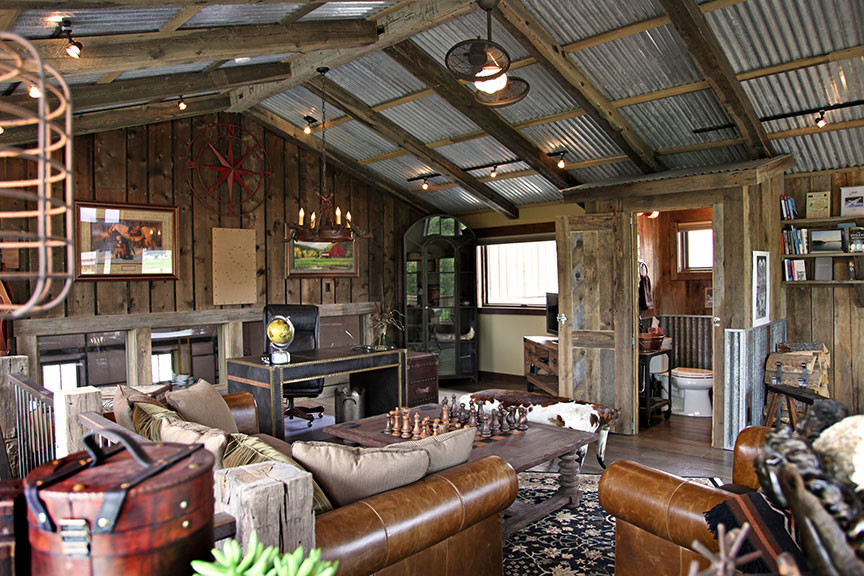Example of a large mountain style freestanding desk dark wood floor and brown floor study room design with brown walls and no fireplace