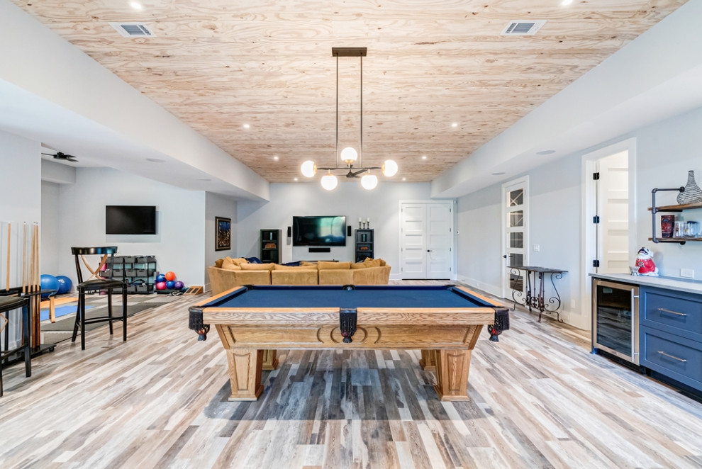 Réalisation d'un sous-sol minimaliste avec salle de jeu, un mur blanc, un sol en vinyl, un plafond en bois et du lambris de bois.