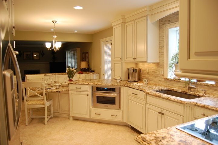 This is an example of a mid-sized traditional u-shaped separate kitchen in Detroit with an undermount sink, raised-panel cabinets, white cabinets, granite benchtops, beige splashback, matchstick tile splashback, stainless steel appliances, limestone floors, a peninsula and beige floor.