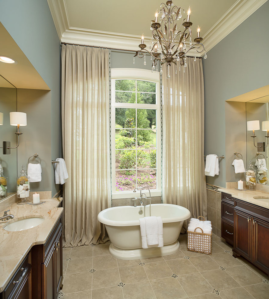 Design ideas for a large traditional master bathroom in Other with raised-panel cabinets, dark wood cabinets, a freestanding tub, a one-piece toilet, blue walls, ceramic floors, an undermount sink and beige floor.