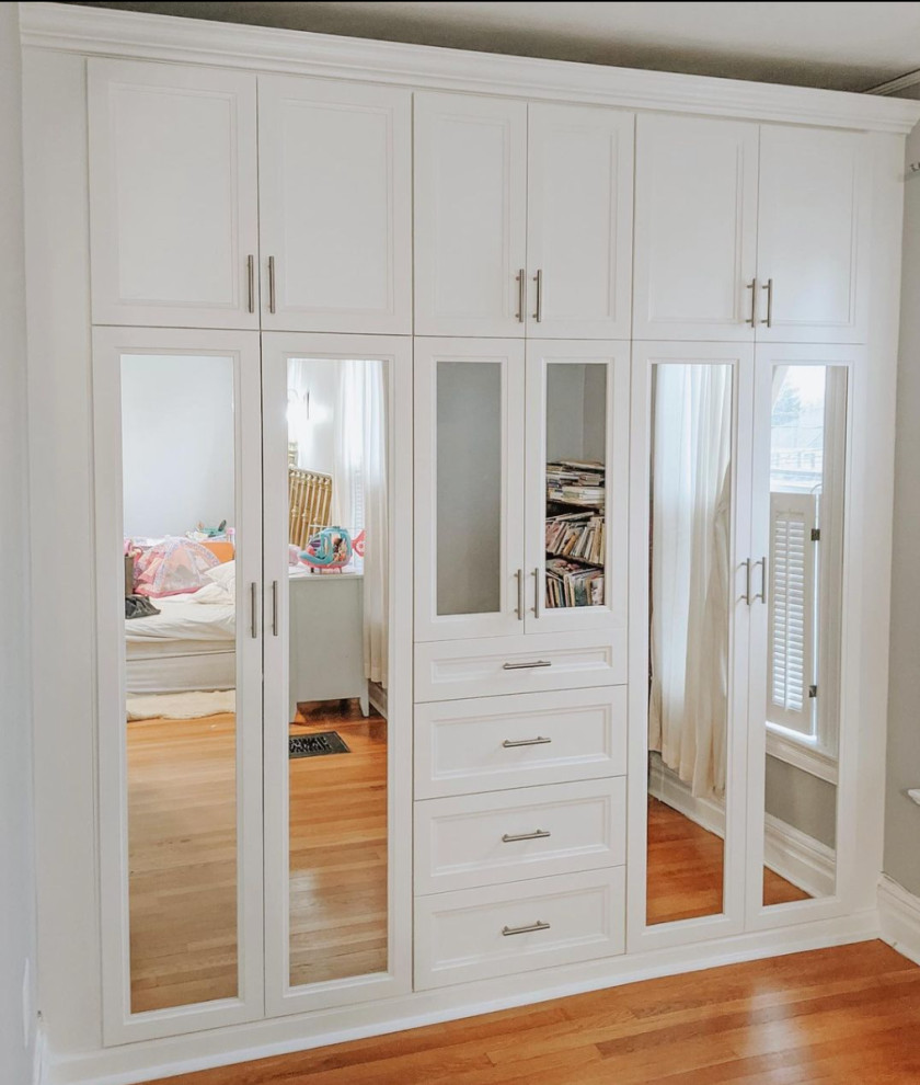 Design ideas for a small traditional women's storage and wardrobe in New York with recessed-panel cabinets, white cabinets, medium hardwood floors and brown floor.