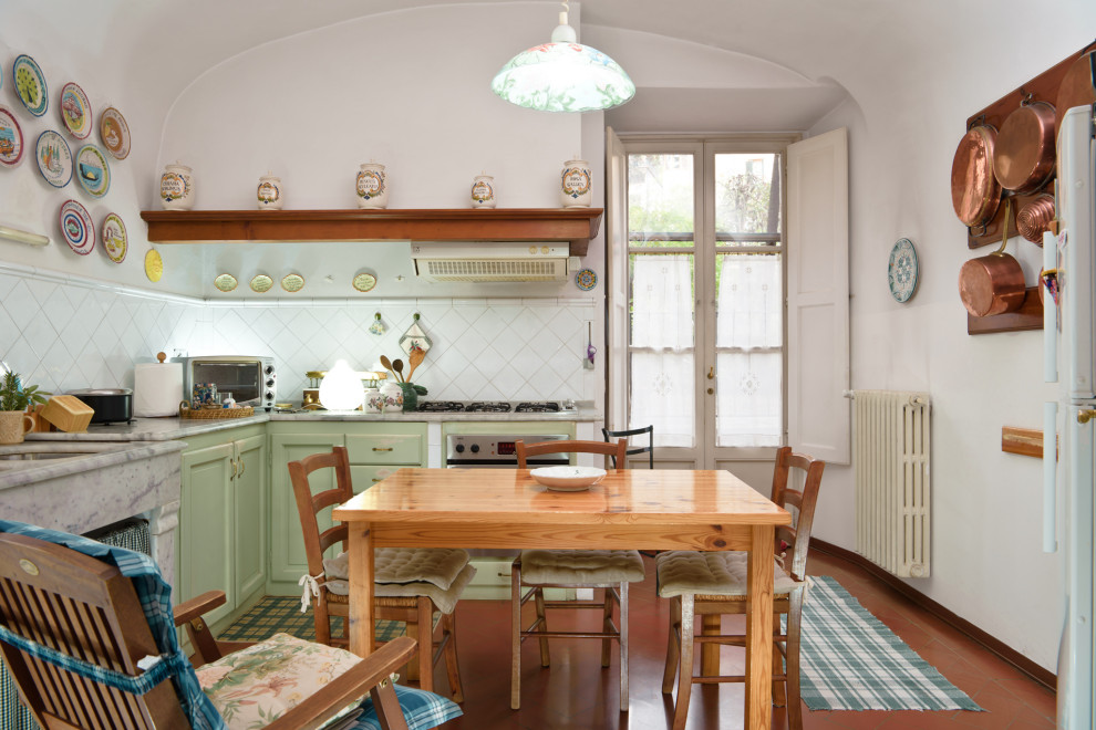 Photo of a small traditional l-shaped eat-in kitchen in Florence with an undermount sink, recessed-panel cabinets, green cabinets, marble benchtops, white splashback, ceramic splashback, stainless steel appliances, terra-cotta floors, orange floor, grey benchtop and vaulted.