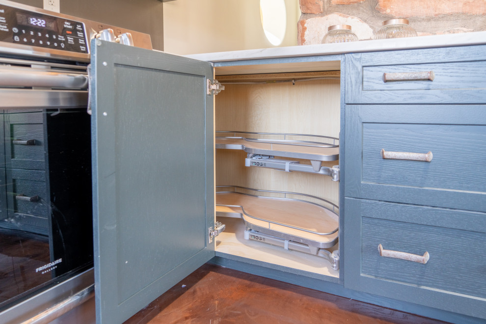 Example of a transitional concrete floor kitchen design with shaker cabinets, blue cabinets and stainless steel appliances