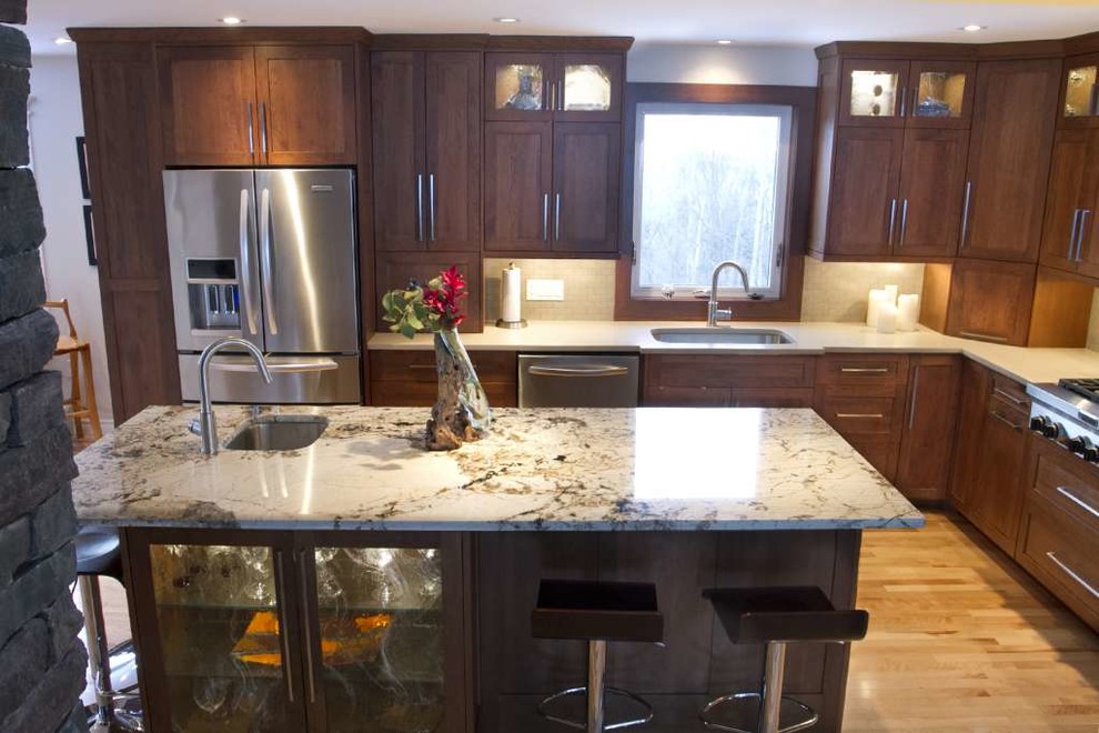 Example of a mid-sized transitional l-shaped light wood floor and beige floor open concept kitchen design with an undermount sink, shaker cabinets, dark wood cabinets, quartz countertops, beige backsplash, porcelain backsplash, stainless steel appliances and an island