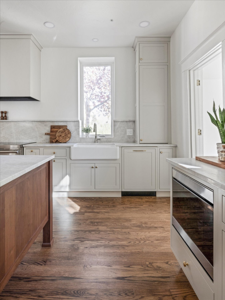 Example of a mid-sized transitional medium tone wood floor and brown floor eat-in kitchen design in Denver with white walls and a standard fireplace