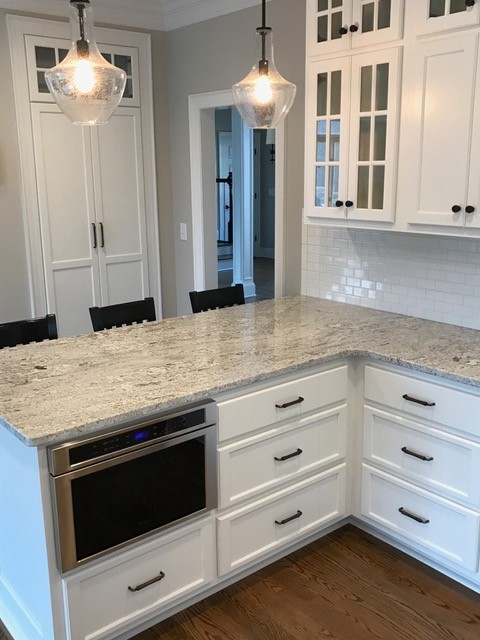 Kitchen - large transitional kitchen idea in Charlotte with recessed-panel cabinets, white cabinets, granite countertops, white backsplash, subway tile backsplash, stainless steel appliances and a peninsula